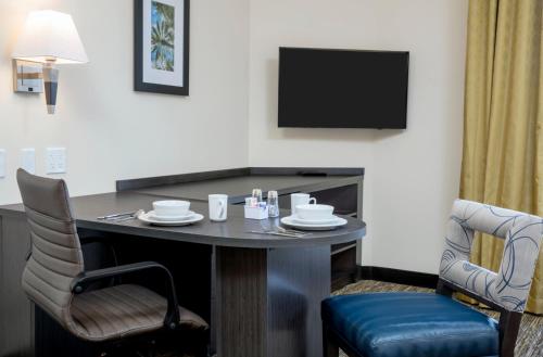 a hotel room with a table and a tv at Candlewood Suites - Miami Exec Airport - Kendall by IHG in Kendall