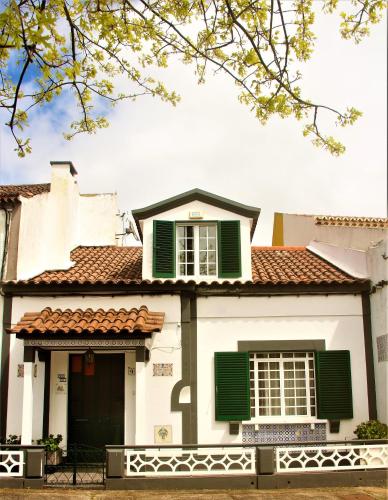 a white house with green shutters at CASA INTI / INTI HOUSE FURNAS in Furnas