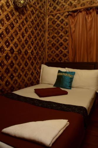 a bedroom with a bed with white sheets and pillows at Bantal Guling Villa in Lembang