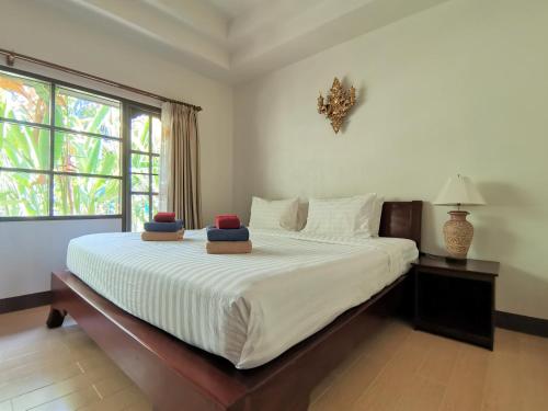 a bedroom with a bed with two pillows on it at Holiday Villa, Lanta in Ko Lanta