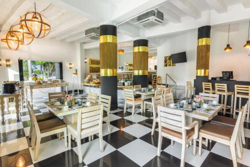 comedor con mesas y sillas en GHL Collection Armería Real Hotel en Cartagena de Indias