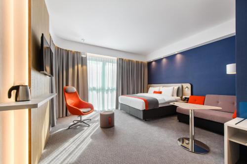 a hotel room with a bed and a desk at Holiday Inn Express - Rzeszow Airport by IHG in Rzeszów