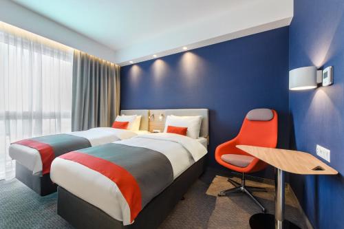 a hotel room with two beds and a chair at Holiday Inn Express - Rzeszow Airport by IHG in Rzeszów
