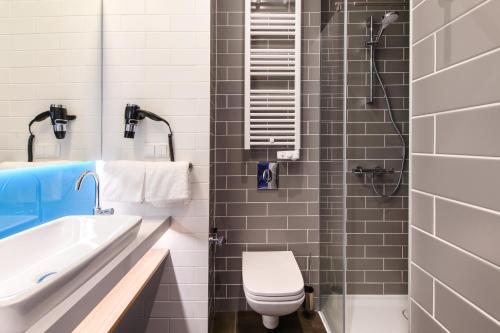 a bathroom with a toilet and a sink and a shower at Holiday Inn Express - Rzeszow Airport by IHG in Rzeszów
