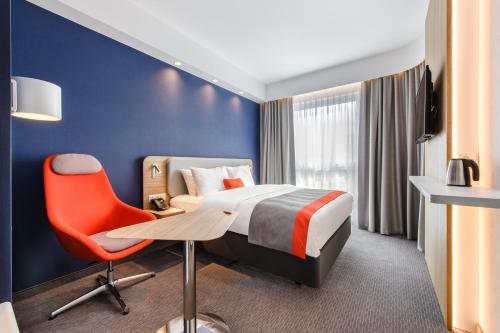a hotel room with a bed and a desk and a chair at Holiday Inn Express - Rzeszow Airport by IHG in Rzeszów