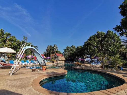a swimming pool with a slide in a resort at Holiday Villa, Lanta in Ko Lanta