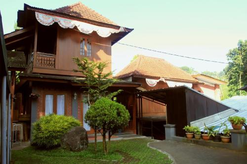 a home with a building with plants in the yard at Bantal Guling Villa in Lembang