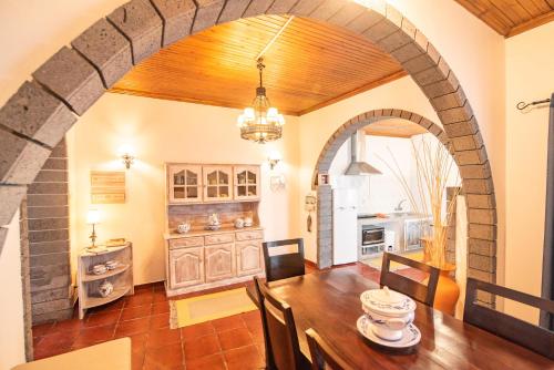 una cocina y comedor con un arco en una casa en CASA INTI / INTI HOUSE FURNAS, en Furnas