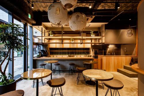 a restaurant with tables and stools in a kitchen at eph TAKAYAMA in Takayama
