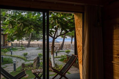 a room with a window looking out at the beach at Buena Vida Beach Resort in Morjim