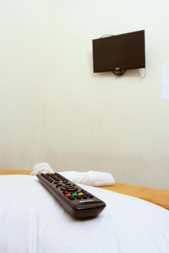 a remote control sitting on top of a bed at Unique Guesthouse in Bandung