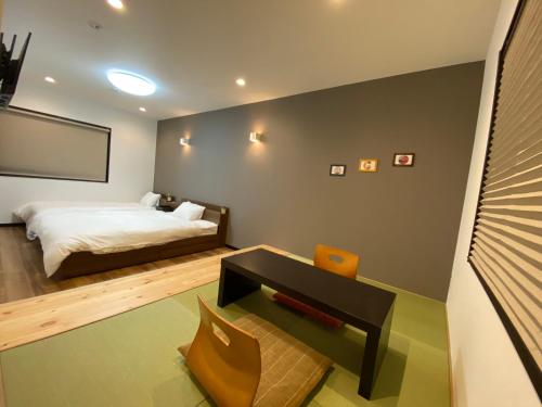 a bedroom with a bed and a table and a chair at KYOTO STATION HOUSE in Kyoto