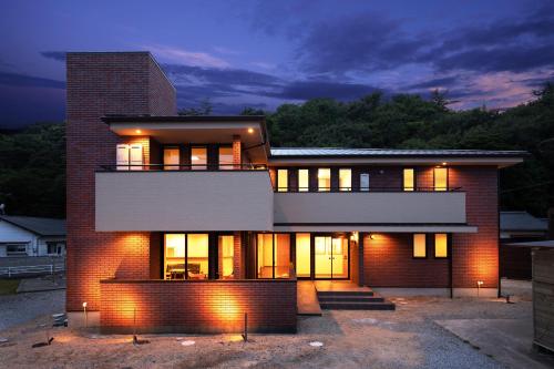 una gran casa de ladrillo con luces encendidas en Wright Style, en Naoshima