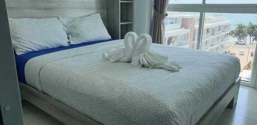 a white angel statue sitting on a bed with a window at Grandblue condominium Room 606 in Mae Pim