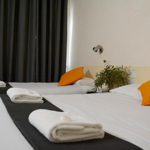 2 camas con toallas en una habitación de hotel en Shamrock Hotel Motel Temora, en Temora