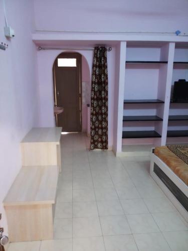 a room with a bed and a table and a door at VS Lodging in Chidambaram
