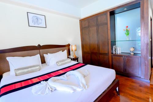 a bedroom with a bed with white sheets and a window at Le Casa Bangsaen in Bangsaen