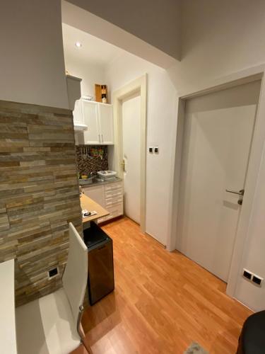 Il comprend une cuisine avec des placards blancs et du parquet. dans l'établissement Dani Apartment, à Rijeka