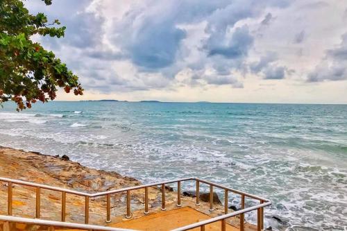 a staircase leading down to the ocean on a beach at Avatara A Ocean Views by malai in Ban Tha Fat