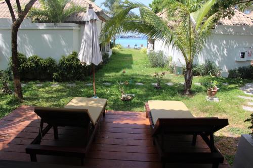 a patio with an umbrella and a table and chairs at Bundhaya Villas in Ko Lipe