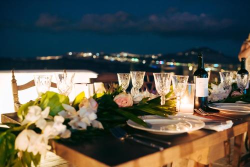 a table with glasses and flowers and wine bottles at Summer Lovers Villa in Akrotiri