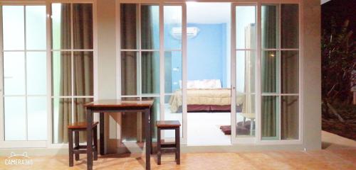 a room with glass doors and two tables and a bed at Khao Thong Home Stay in Krabi town