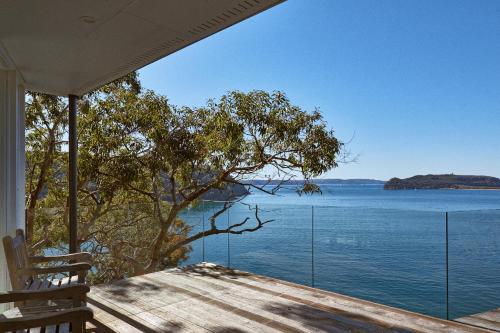 a house with a view of the water at Cape Mackerel Cabin with Magic Palm Beach & Pittwater Views in Great Mackerel Beach