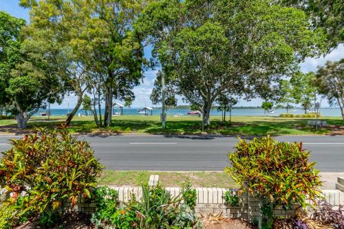 um parque de estacionamento vazio com árvores e uma rua em Keith's Place, 1 of the 4 most popular units on Bribie em Bongaree