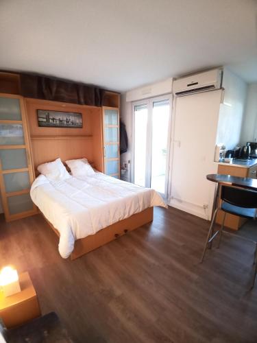 une chambre avec un grand lit et un bureau et une fenêtre dans l'établissement Studio Santa Monica - Climatisé - Piscine - Parking, à Toulouse
