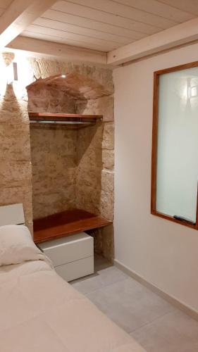 a bedroom with a bed and a stone wall at B&B il castello suite in Giovinazzo
