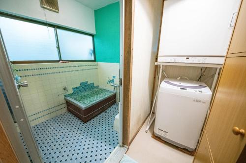 a bathroom with a shower and a tub and a toilet at 一棟貸し宿Kusuburu House chartered accommodation in Okinoshima