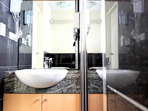 a bathroom with two sinks and a shower at Entire Studio Apartment in St Kilda FREE PARKING WIFI BEACH WALK in Melbourne