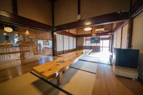a large room with a long wooden table in it at private accommodation隠岐貸切古民家宿くすぶるハウス in Okinoshima