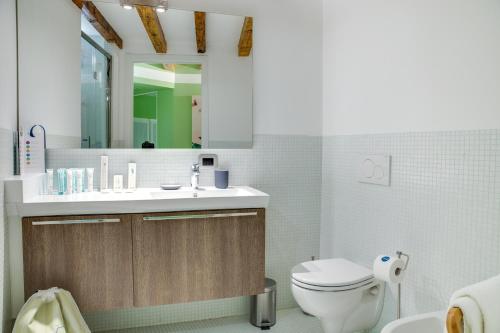 ein Badezimmer mit einem WC, einem Waschbecken und einem Spiegel in der Unterkunft Sweet Inn - Corridoni in Mailand
