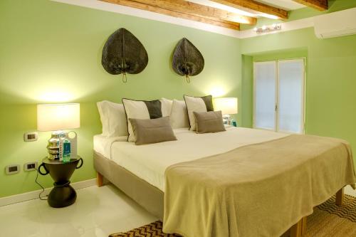 a bedroom with a large bed with green walls at Sweet Inn - Corridoni in Milan