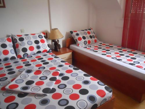 two beds with polka dot sheets in a bedroom at Nikolic Apartments - Ohrid City Centre in Ohrid