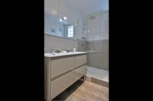 une salle de bain avec un lavabo, un miroir et une baignoire dans l'établissement Le Grand Joliette Marseille 