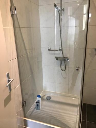 een douche met een glazen deur in de badkamer bij Kampen NL 28-1 in Kampen