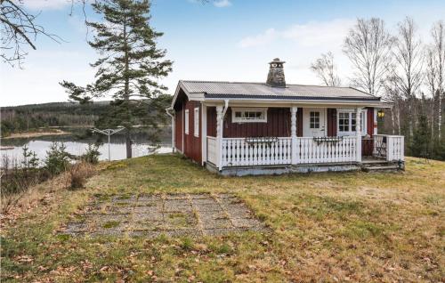 a red house with a white porch on a yard at Pet Friendly Home In Gunnarskog in Gunnarskog