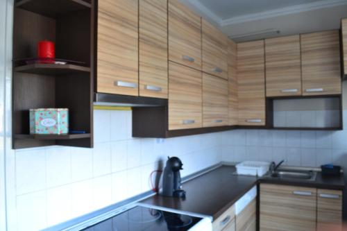 a kitchen with wooden cabinets and a black counter top at Chill Apartman in Komárom