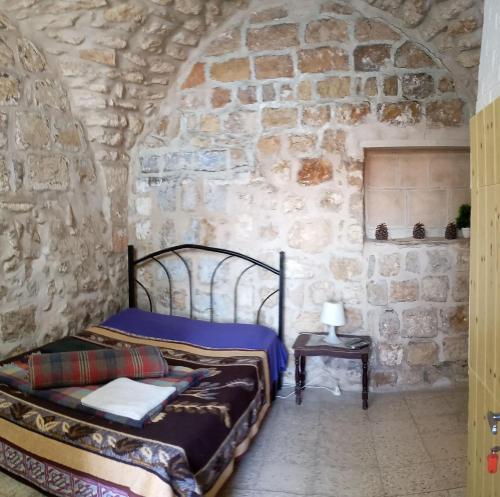 a bedroom with two beds and a stone wall at Jaffa Gate Hostel in Jerusalem