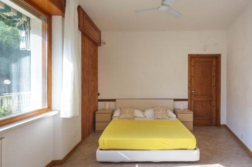 ein Schlafzimmer mit einem gelben Bett und einem Fenster in der Unterkunft A Casa di Mila - Appartamento con piscina in Sori