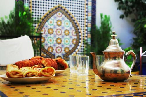 - une table avec une assiette de nourriture et une bouilloire dans l'établissement House Zitouna, à Marrakech