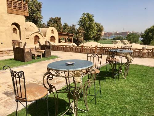 a group of tables and chairs in a yard at Djorff Palace in Luxor
