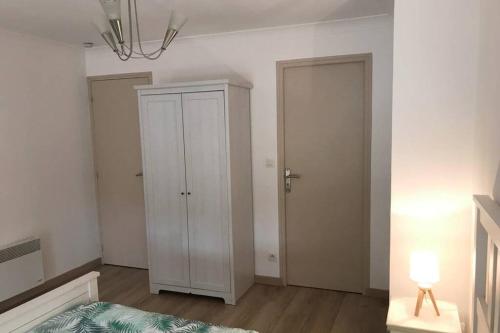 - une chambre avec un placard blanc et une porte dans l'établissement Au pied du phare..., à Honfleur