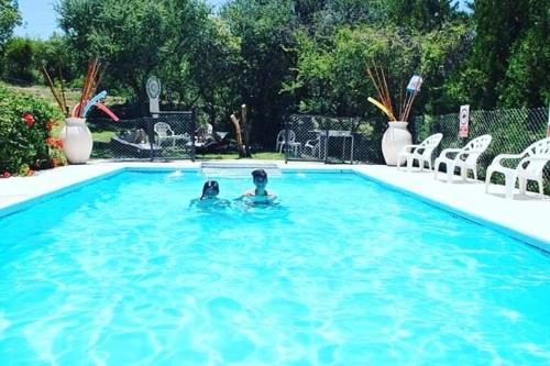 a couple of people in a swimming pool at Cabañas Thijada in Mina Clavero