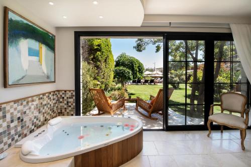 a jacuzzi tub in a room with a patio at Alacati Kapari Hotel - Special Category in Alacati