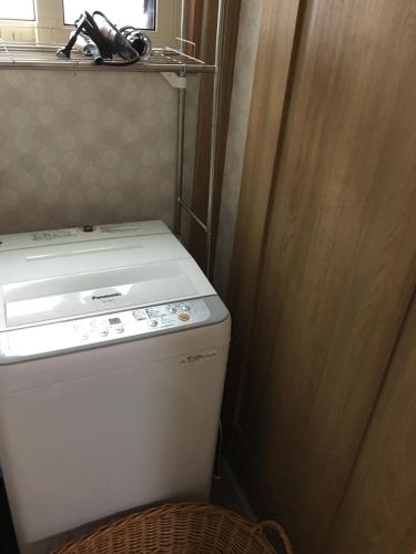 a small bathroom with a toilet and a wooden door at ゲストハウス蘖 -ひこばえ in Kitakami