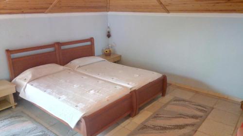 a bedroom with a wooden bed in a room at Attic of Mary in Nea Roda