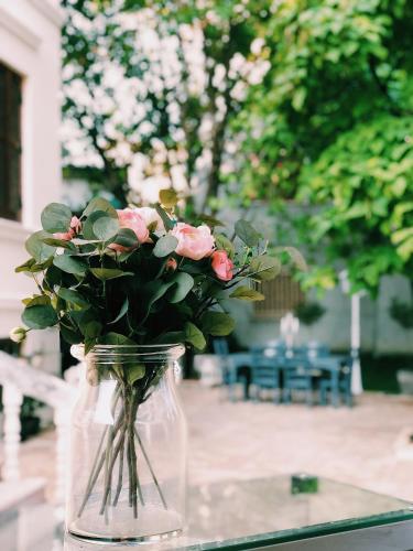 a vase filled with pink roses sitting on a table at Seven cafe & hotel in Pogradec